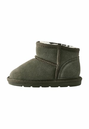 Bottine en suède verte avec un bout arrondi, doublure douce et piqûre contrastante. Elle dispose d'une semelle plate avec une texture antidérapante.