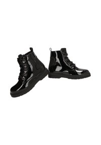 Botines de charol negro con punta redonda, frente de cordones y un panel texturizado en el costado. Presentan suelas de goma resistentes.