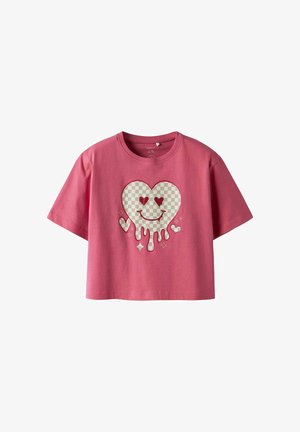 Camiseta corta rosa con un gran gráfico de un corazón a cuadros con bordes goteando, pequeños corazones y acentos brillantes.