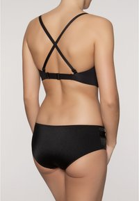 Melna bikini ar krustveida siksnām aizmugurē. Augšdaļai ir regulējama aparatūra; apakšdaļām ir gluda tekstūra ar sānu akcentiem.