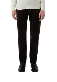 Dark brown corduroy pants with a slim fit design, featuring a soft texture and subtle vertical ridges, paired with black shoes.
