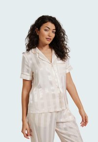 Silky cream pajama set with subtle vertical stripes, featuring short sleeves, a notch collar, chest pocket, and gold-tone accents.