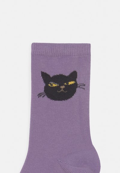Meias roxas com um design de rosto de gato preto tricotado, apresentando olhos amarelos e bigodes, feitas de um tecido macio e texturizado.