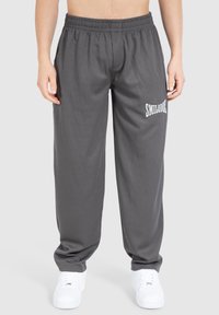 Grå ribbede sweatpants med elastisk talje, der har et hvidt "SMILLOOK" logo på venstre lår og lige ben.