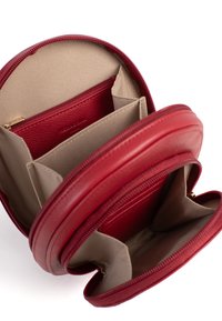 Borsa rotonda in pelle rossa con chiusura a zip. All'interno presenta più scomparti e una fodera beige. Esterno testurizzato con un marchio discreto.