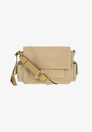 Sac bandoulière en daim beige avec rabat, sangle d'épaule réglable, deux poches latérales et tirette de fermeture éclair à pompon sur le côté gauche.