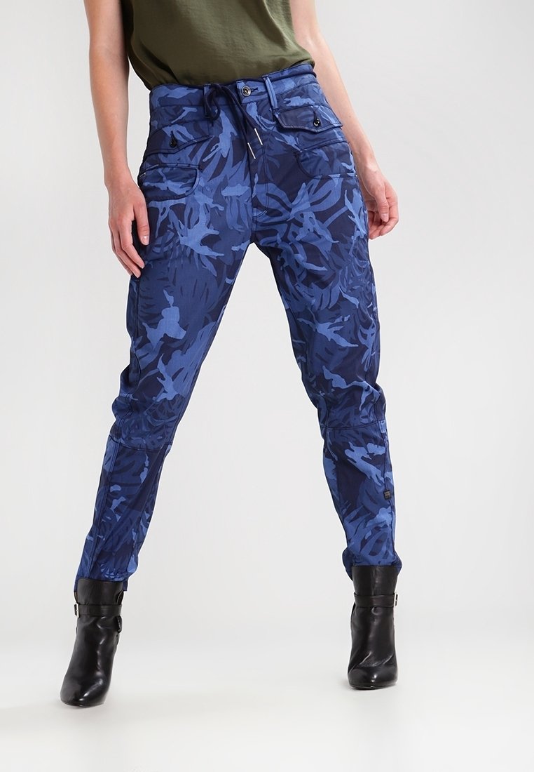 Blå kamouflage cargo-byxor med elastisk midja, två framfickor och tapered ben, tillverkade av ett lätt och strukturerat tyg.