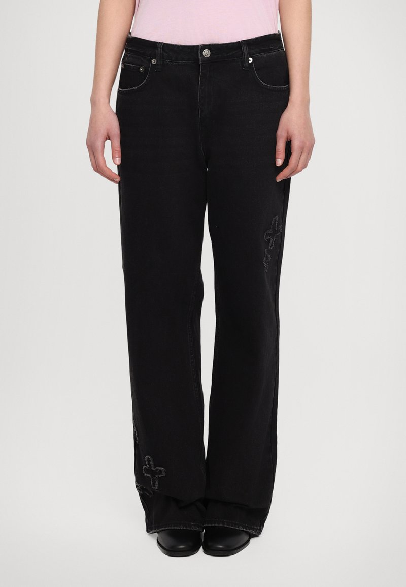 Svarta vida jeans med en urtvättad finish, med dekorativ sömnad vid nedre delen av benen och femfickorsdesign. Tillverkade av denim.