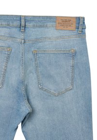 Jeans in denim azzurro chiaro con una texture liscia, dotati di due tasche posteriori, cuciture a contrasto e un'etichetta in pelle che dettaglia il marchio.