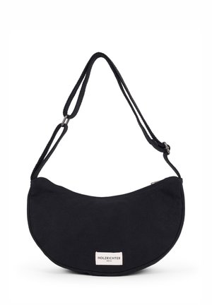 Schwarze Stofftasche mit geschwungener Form, verstellbarem Tragegurt und einem kleinen Etikett. Glatte Textur ohne zusätzliche Muster oder Akzente.