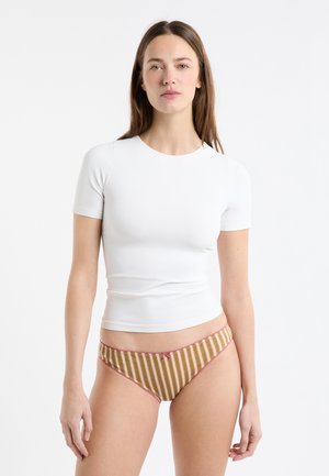 Biała, dopasowana koszulka z krótkim rękawem w zestawieniu z pasiastymi, brązowo-złotymi dół bikini z różowym wykończeniem i kokardką.