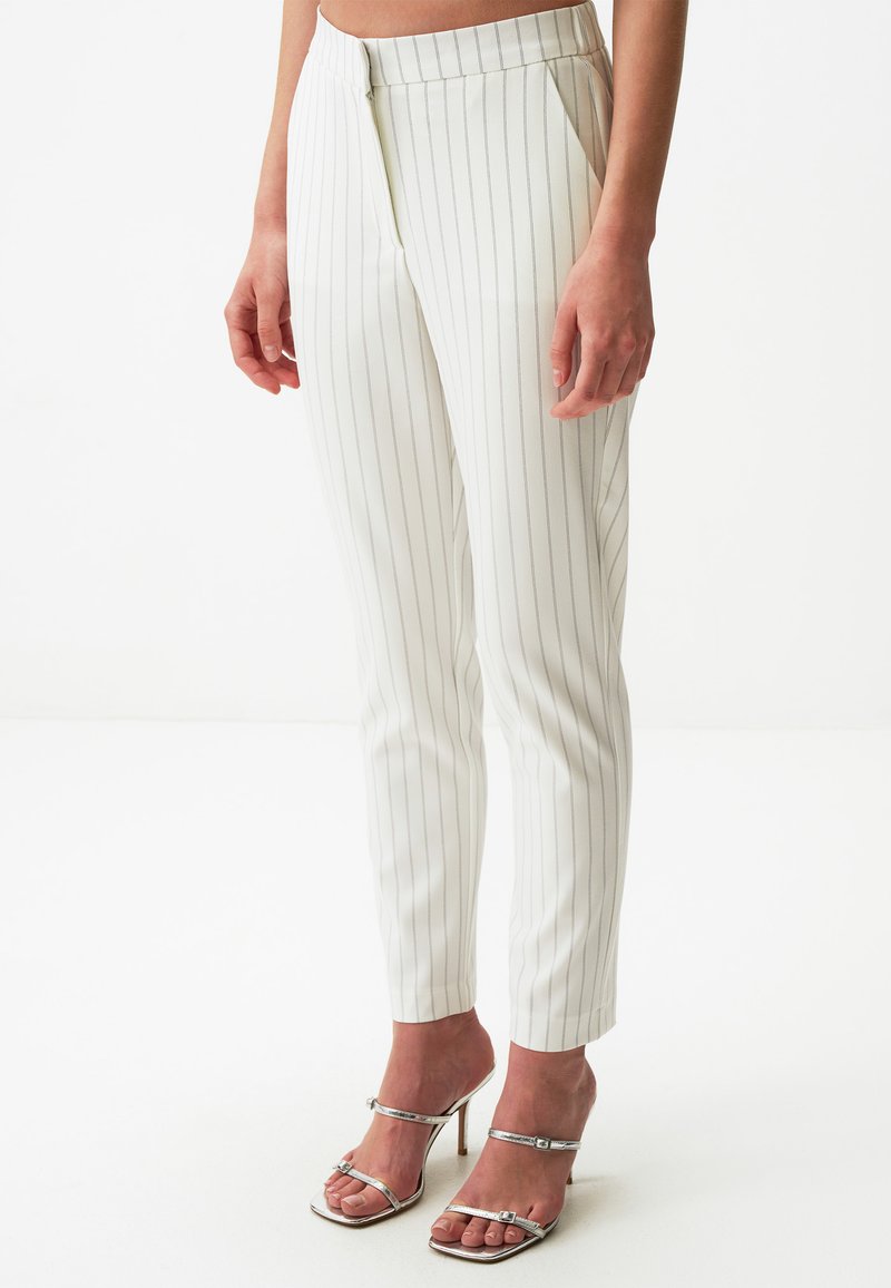 Witte pinstriped broeken in een getailleerde pasvorm met een gladde textuur en een verborgen rits. G gecombineerd met zilveren strappy hakken.