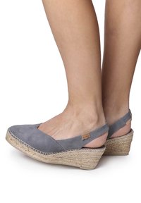 Gray suede wedge shoes with an open back, jute-wrapped heel, and a stitched detail along the sole. Sleek design with a comfortable fit.