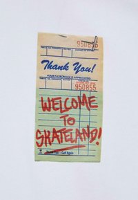Betalingskvittering i vintage stil, cremefarvet papir med blå tekst og rød håndskrevet "VELKOMMEN TIL SKATELAND!" Klips øverst.
