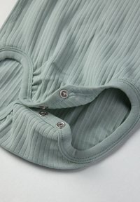 Ribbed minttuvihreä kangasbody, jossa on nepparit kaula-aukossa. Pehmeä rakenne sovitettu muotoilu ja lyhyet hihat.