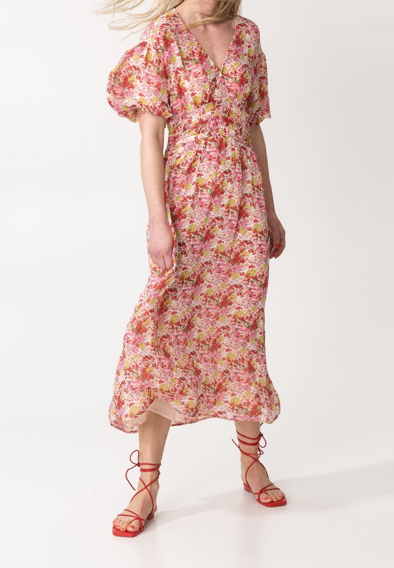 Květinové midi šaty v růžové, žluté a zelené barvě s nabíranými rukávy a výstřihem do V. V kombinaci s červenými sandály na klínu. Lehká, splývavá tkanina.
