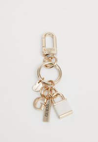 Breloc din metal cu finisaj auriu, având un clips, inele metalice și charme decorative, inclusiv o lacăt și etichete cu branding "GUESS".
