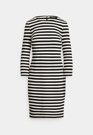 Haljina s crnim i kremastim prugama, s izrezom u obliku lađe, dugim rukavima i patentnim zatvaračem na leđima. Sadrži gumbe na ramenima s pozlatom.