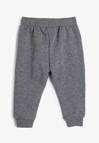 Pantalones jogger de algodón gris con cinturilla y puños acanalados, que presentan una textura suave y un corte holgado para mayor comodidad.