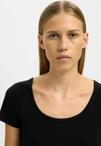 Sort bomulds t-shirt med rund halsudskæring og korte ærmer, med en glat tekstur og enkelt design.