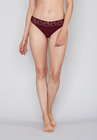 Burgundy lace-accents hipster underwear with a smooth finish and a low-rise design, featuring floral pattern and elastic waistband.