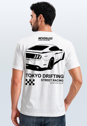 Man wearing white T-shirt with black graphic of a sports car and text "Neverless Classic Racing," "Tokyo Drifting Street Racing," and checkered flag design.