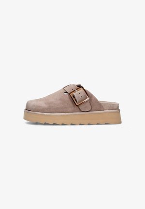 Zoccolo in suede marrone con una larga fascia e una fibbia metallica rettangolare. Presenta una suola chunky beige testurizzata con bordi a zigzag.