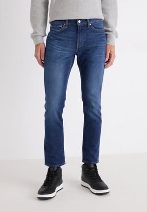 Donkerblauwe denim jeans, slim fit, met een medium taille, voorzien van voorzakken, subtiele stiksels en een standaard knoopsluiting.