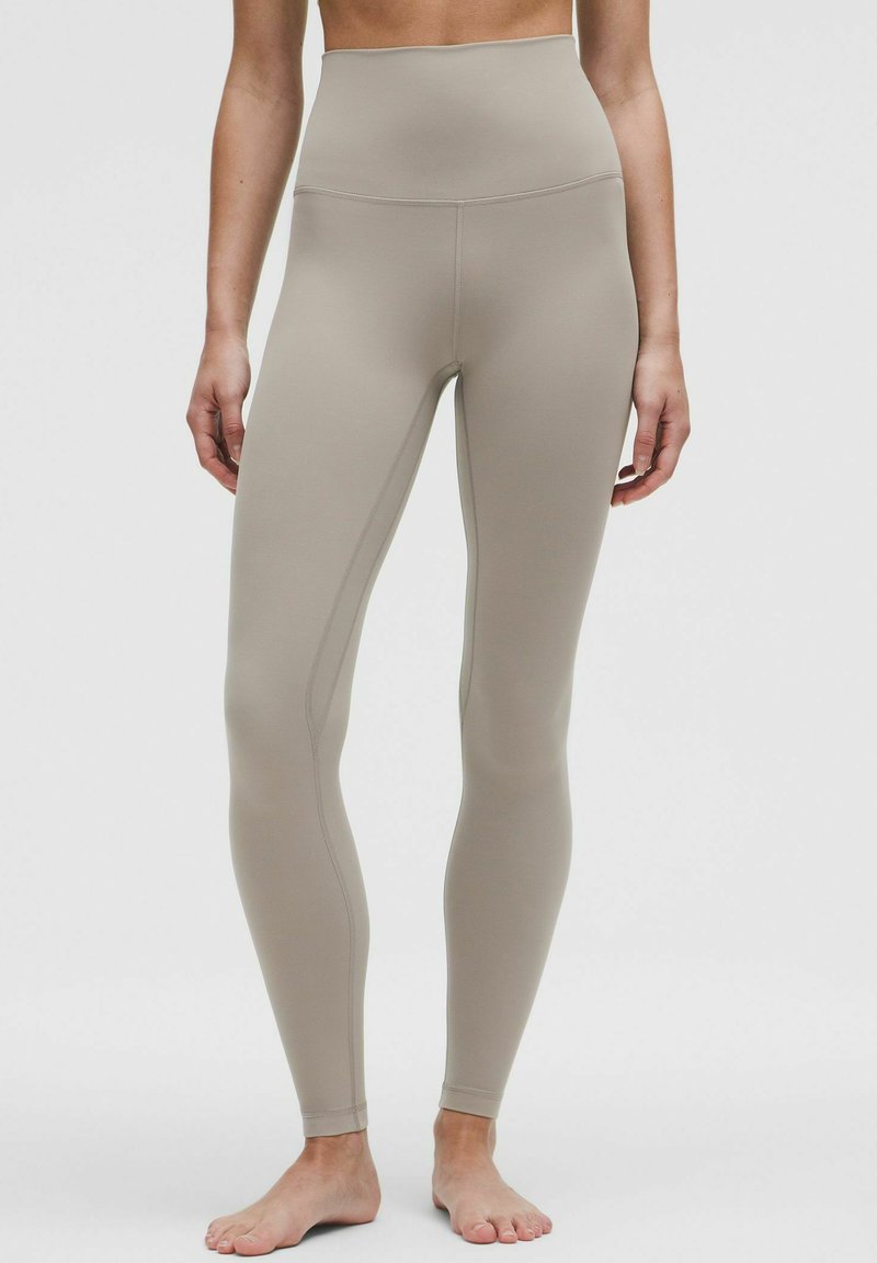 Beige Leggings mit hoher Taille aus elastischem Stoff, mit glatter Textur, figurbetontem Schnitt und dezenten N�ähten.