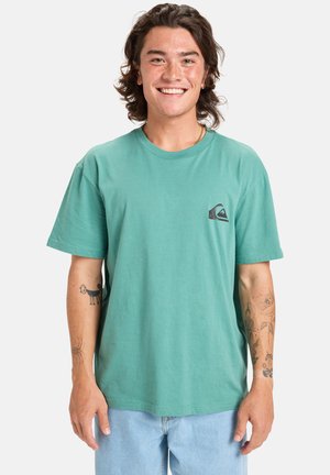 Muntgroene katoen t-shirt met een ronde hals en korte mouwen. Het heeft een klein donker logo op de linkerkant van de borst. Casual pasvorm.