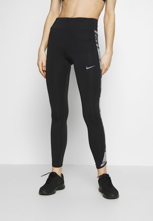 Mustat korkean vyötärön legginsit, jotka on valmistettu elastisesta kankaasta. Niissä on harmaa sivupaneeli, jossa on painettu Nike-logoa, ja ne omaavat sileän ja kiiltävän pinnan.