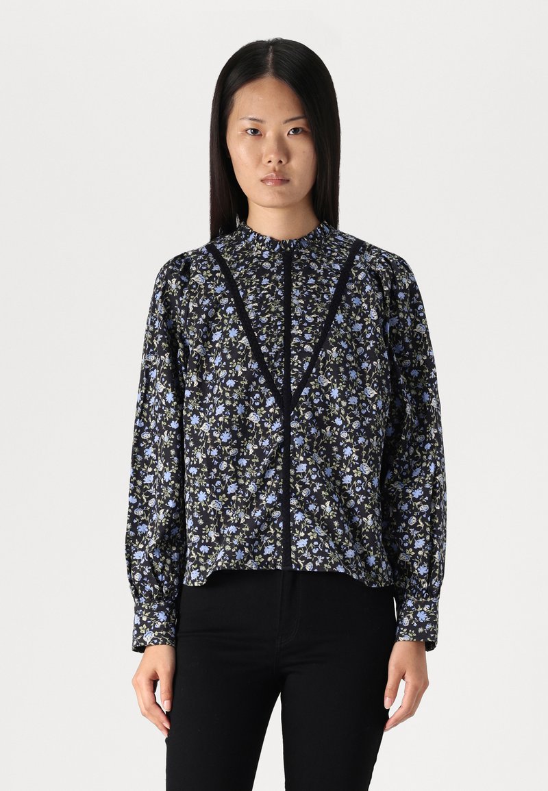 Blusa a fiori nera e blu con colletto alto, maniche lunghe a sbuffo e chiusura con bottoni frontale. Realizzata in tessuto leggero.