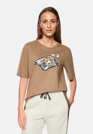 Brown cotton t-shirt with short sleeves, featuring a graphic of a dog and a thought bubble. Paired with cream pants with drawstring closure.