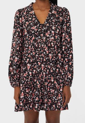 Zwart bloemenjurk met lange poefmouwen, een V-hals, geplooide details en een uitlopende rok, versierd met roze en witte bloemen.