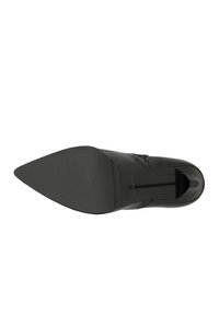 Scarpa nera in pelle con punta affilata e superficie liscia, tacco quadrato e suola in gomma. Presenta un design sottile sulla parte superiore.