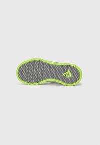 Suela de zapato con una base de goma gris y un patrón texturizado, acentuada por un borde verde brillante. Incluye un logo de Adidas en la esquina.
