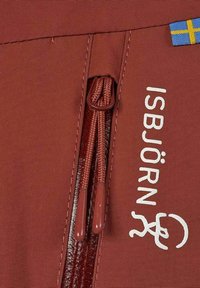 Röd tyg med en slät textur har en dragkedjestängning. Märket "ISBJÖRN" är tryckt i vitt, och en liten svensk flagga syns.
