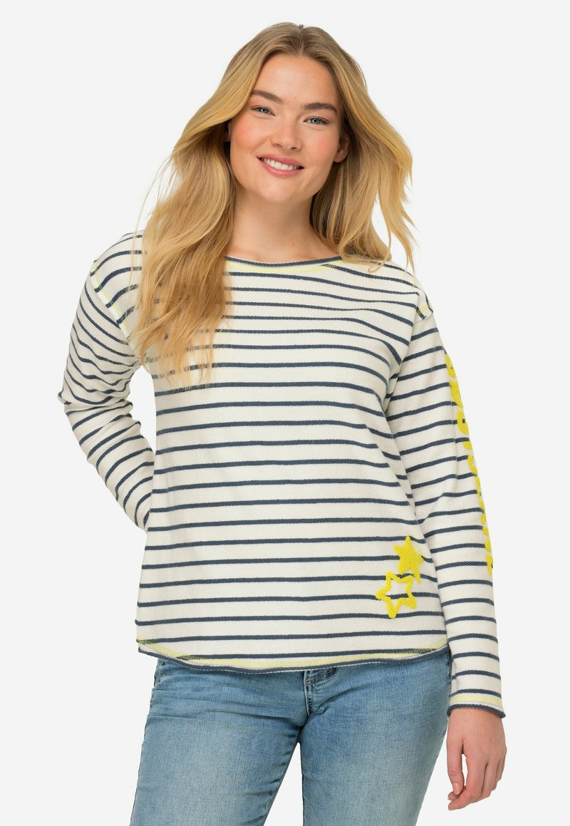 Maglietta a maniche lunghe a righe in crema e blu navy, con accenti gialli a forma di stella a sinistra e motivo a righe su tutto il capo. Vestibilità casual e texture morbida.