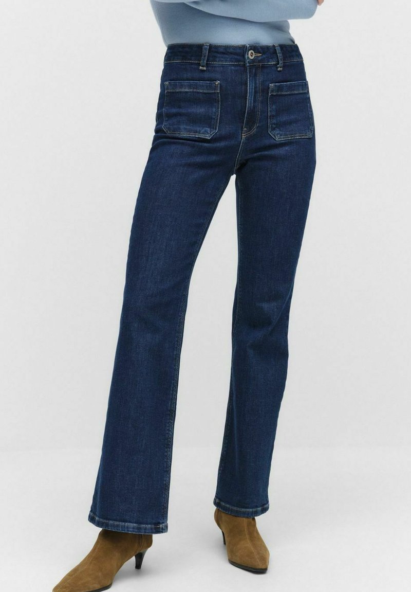 Tummansininen denim-mallinen liehuva hame, jossa on keskipitkä vyötärö, viisi taskua ja kontrastivärinen ompelu. Suora leikkaus polvesta helmaan.