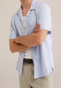 Kortärmad skjorta med ljusblå och vita ränder, lättviktsmaterial, avslappnad passform och design med campkrage.