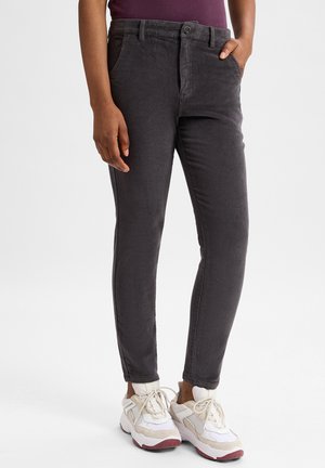 Grijze corduroy broek met slim fit, met voorzakken en een knoopsluiting. Gecombineerd met witte sneakers met beige accenten.