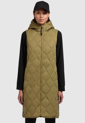 Gilet long matelassé vert olive avec capuche, fermeture éclair frontale et accents latéraux, fabriqué en tissu lisse et arborant un motif texturé.