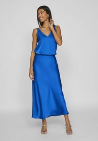 Abito blu in satin con scollatura a V, spalline sottili e design fluido. Tessuto liscio, lunghezza alla caviglia, con vita arricciata.