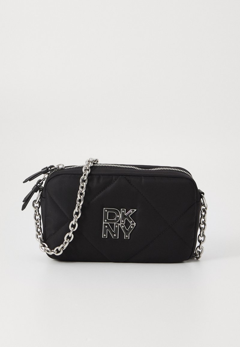 Black quilted handbag with a silver chain strap, featuring a metallic DKNY logo on the front and zip closure at the top.