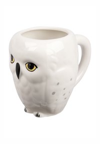 Mug in ceramica bianca a forma di gufo, con occhi gialli, becco nero e piccoli piedi neri. Presenta motivi di piume testurizzati sulla superficie.