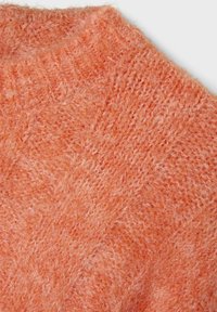 Sweter dzianinowy w miękkiej, puszystej pomarańczowej włóczce z okrągłym dekoltem i teksturowanymi, wypukłymi wzorami. Materiał wydaje się ciepły i zachęcający.