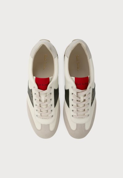 Paire de baskets en cuir blanc avec des bandes latérales vert olive, des bouts beige, des accents rouges sur la languette et des lacets beiges, vues de dessus.