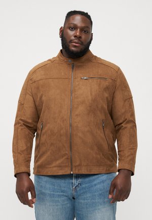 Veste en daim marron avec un col haut, fermeture éclair à l'avant et deux poches latérales. Elle possède une poche zippée sur la poitrine et une surface texturée.
