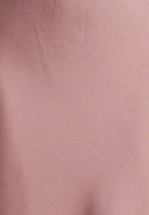 Tessuto rosa pallido con una superficie liscia e una leggera lucentezza, caratterizzato da pieghe sottili e un aspetto uniforme.