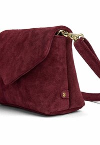 Mala burgundska torbica od brušene kože s preklopnim zatvaračem i odvojivim remenom pričvršćenim zlatnim kopčama.